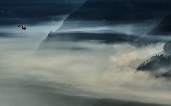 Ein Helikopter der Rega taucht in den Nebel ein