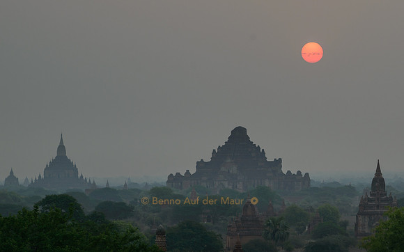 Über dem Dhammayangyi steigt die Sonne als roter Feuerball auf