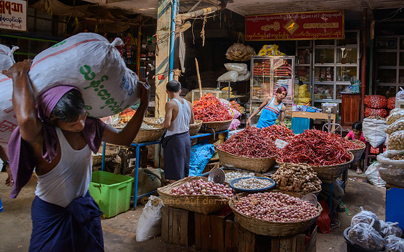 Auf dem Markt von Mawlamyaing werden Säcke voll Waren von Trägern