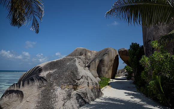 Ein Felsen scheint sich vor den Strandgästen zu verbeugen