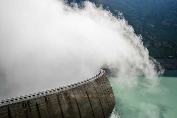 Nebel schwappt über die Staumauer des Lac de Moiry