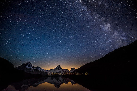 Wetterhorn, Schreckhorn und Finsteraarhorn spiegeln sich in Bergsee. Darüber Sternenhimmel mit Milchstrasse