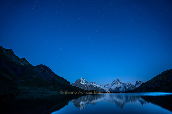 Wetterhorn, Schreckhorn und Finsteraarhorn spiegeln sich in Bergsee. Darüber der Sternenhimmel